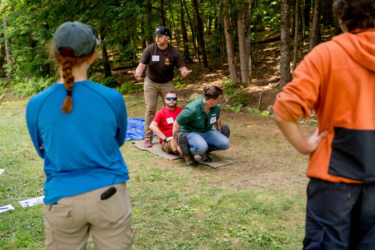 teen building natural debris shelter as part of outdoor survival skills for teens