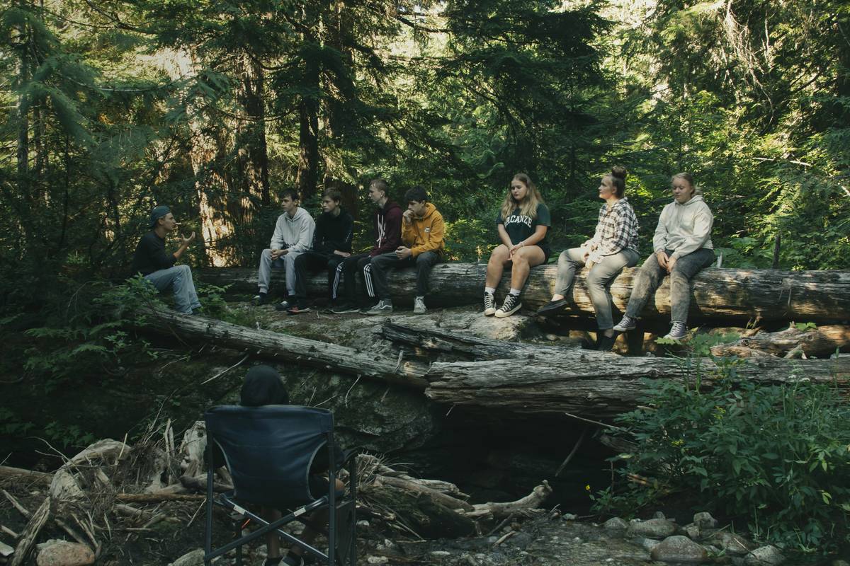 group of teens practicing outdoor survival skills for teens including fire building and navigation